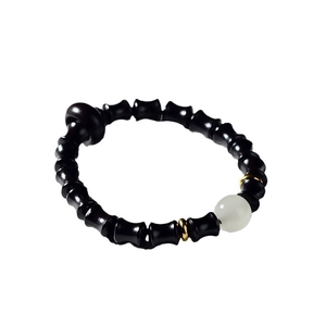 Bracelet en bois de santal avec perle blanche et entretoises dorées sur fond blanc