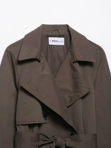 Detailansicht des Trenchcoat-Kragens und des BBWM WOMAN Etiketts in der Größe S