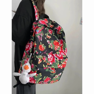 Side view of large capacity floral backpack with duck pendant and retro flower pattern