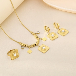Dettaglio set di gioielli placcati in oro con catena a serpente e cristalli quadrati