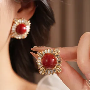 Vintage gold stud earrings with large red zircon centerpiece and floral halo design