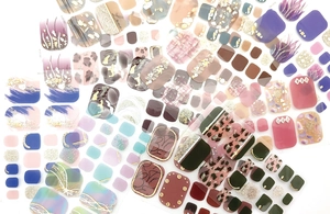 Detail view of waterproof toe nail stickers with gold foil, glitter and diverse patterns