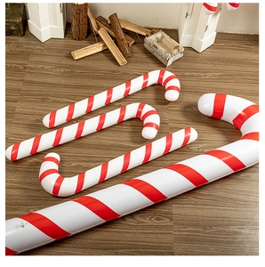 Close-up of inflatable red and white striped Christmas candy cane on wooden floor