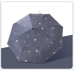 Detail of blue folding umbrella featuring cute cartoon dog and heart print patterns
