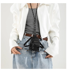 Close-up of black lychee grain leather mini bag with adjustable woven shoulder strap