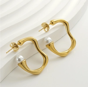 Close-up of 18K gold irregular wave earrings with white pearls on a display stand