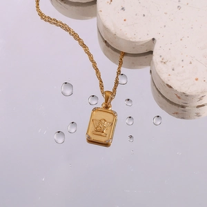 Gold angel embossed square pendant necklace with zircon on a reflective mirror base