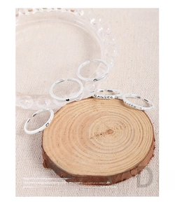 Detail of 5-piece S925 silver ring set with Smile and Lucky engravings on wood base
