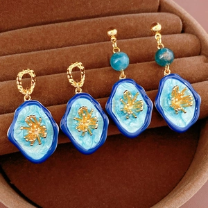 Detailed view of vintage blue enamel flower earrings with gold-plated metal accents