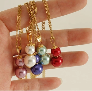 Detail of five 18k gold gourd pendants with colorful pearls in purple, white, and blue