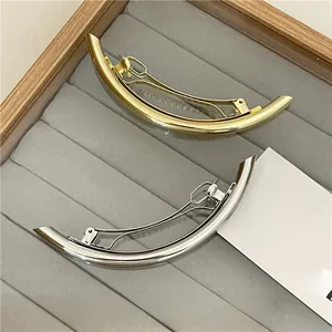 Polished gold and silver minimalist metal hair clips on a premium velvet jewelry tray