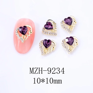 Makroansicht von lila Herz-Strasssteinen und goldenen Love-Nailart-Anhängern in 10x10mm