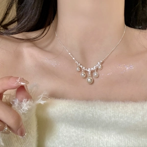 Detailed view of elegant vintage zircon necklace featuring delicate hanging pearls worn on neck