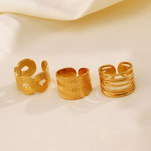 Three-piece gold stainless steel geometric rings set on elegant white satin fabric