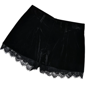 Detail einer schwarzen Samt-Shorts mit zartem Spitzenbesatz und eleganten Falten