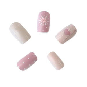 Unghie finte rosa con motivi a cuore, pois bianchi e delicati fiocchi di neve