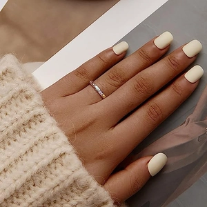 Detailopname van regenboogring met zirkonia gedragen over een gebreide mouw