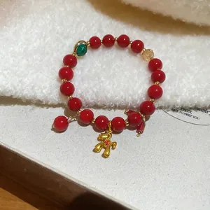 Red beaded bracelet with a golden horse charm and green faceted beads in a New Chinese style