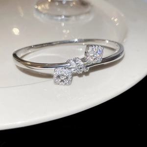 Vue macro d'un jonc ouvert argenté avec des carrés floraux sertis de zircons