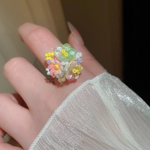 Dettaglio dell'anello a fiore in perline fatto a mano con petali verde pastello