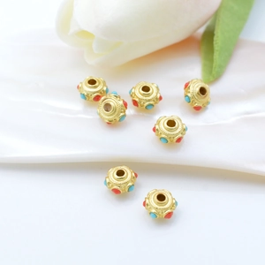 Ancient gold DIY spacer beads with red and blue enamel on white shell backdrop