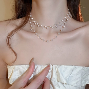 Gros plan d'un collier de perles multicouche avec des chaînes dorées élégantes
