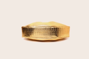 Detailed bottom view of golden crocodile textured clutch with elegant pleated design
