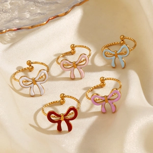 Colorful enamel bow rings in gold stainless steel on soft white silk background