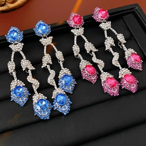 Detail of vintage flower tassel earrings with blue and pink rhinestones in a velvet box