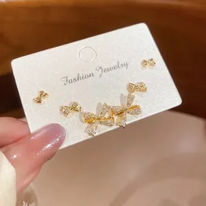 Elegant 18k gold plated bow stud earring set with sparkling zircons on jewelry card