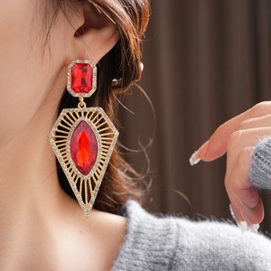 Detail of vintage palace style earrings with red gemstones and sparkling crystals