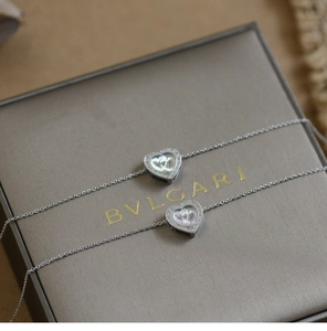 Macro shot of silver heart pendants with crystal accents on a jewelry gift box