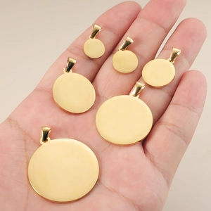 Polished gold stainless steel round pet ID tags in various sizes held in hand
