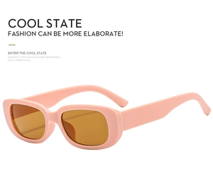 Detail showing retro rectangular pink sunglasses with orange amber lenses and matte texture