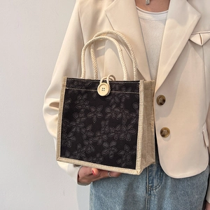 Chic black floral embroidered tote bag with wooden accents and white woven rope handles