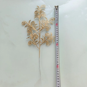 Gros plan d'une feuille dorée ajourée avec règle montrant la longueur de 38cm