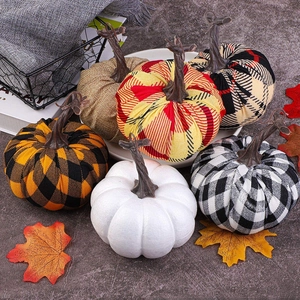 Close-up of assorted plaid fabric and foam artificial pumpkins for autumn home decor