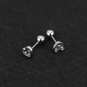 Detailed macro view of heart-shaped zircon ear studs with secure screw ball back closure