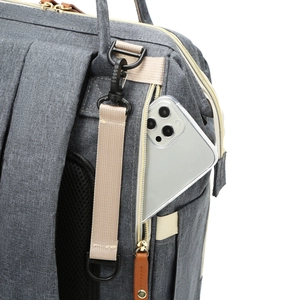 Gray canvas diaper backpack with anti-theft back pocket and gold zippers for strollers