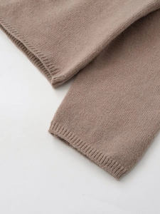 Macro view of camel knit sweater showing soft ribbed cuff texture and fine weaving details