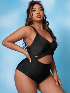 Detail of plus size black one-piece swimsuit with crossover design and waist cut-out