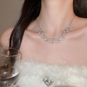 Close-up of silver-plated fringe necklace with rhinestones and pearls on model