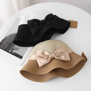 Detailed straw texture and elegant ribbon bow on a color-block summer sun hat