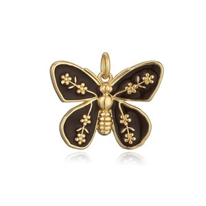 Detail of butterfly pendant with gold finish, black enamel wings and floral patterns