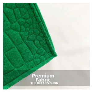 Detailed close-up of green crocodile-embossed faux leather texture on the stylish handbag
