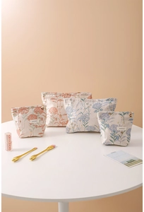 Detail of four-piece floral jacquard toiletry bags with elegant embroidery and metal zippers