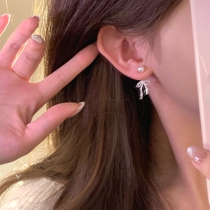 Silver bow and pearl earrings set for women featuring French retro design on a model