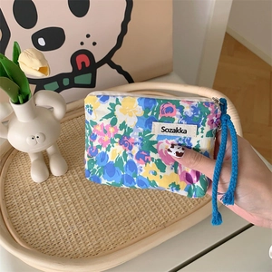 Close-up of Japanese style floral fabric pouch with colorful drawstring zipper and Sozakka tag