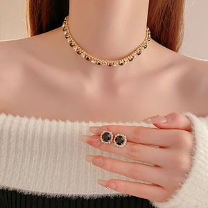 Detail of choker necklace and square earrings set with black and clear crystals