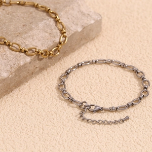 Close-up of dual-tone gold and silver stainless steel chain anklets with lobster clasp
